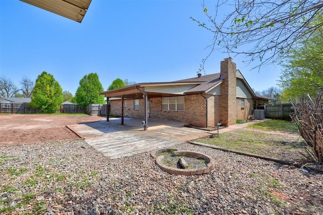 1809 W Aqua Clear Dr, Mustang, OK 73064 - back of house featuring a patio area, a fenced backyard, central AC unit, and a chimney