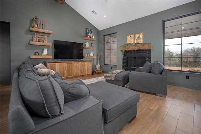 2040 County Road 1336, Blanchard, OK 73010 - living area with light wood-style floors, high vaulted ceiling, visible vents, a brick fireplace, and baseboards