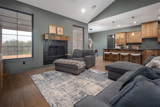 2040 County Road 1336, Blanchard, OK 73010 - living area featuring a brick fireplace, dark wood finished floors, visible vents, and recessed lighting