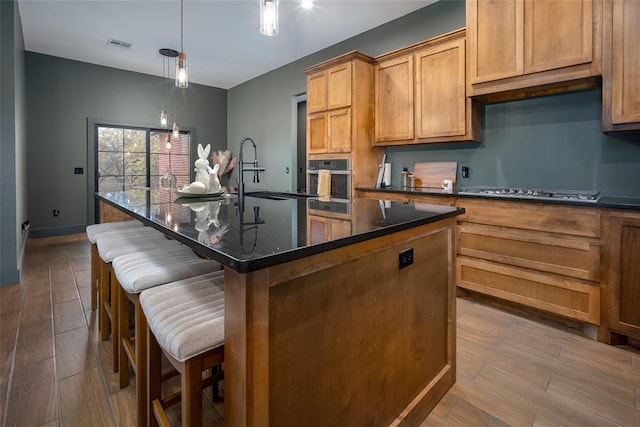 2040 County Road 1336, Blanchard, OK 73010 - kitchen featuring visible vents, a kitchen island with sink, a kitchen bar, stainless steel appliances, and dark wood-type flooring