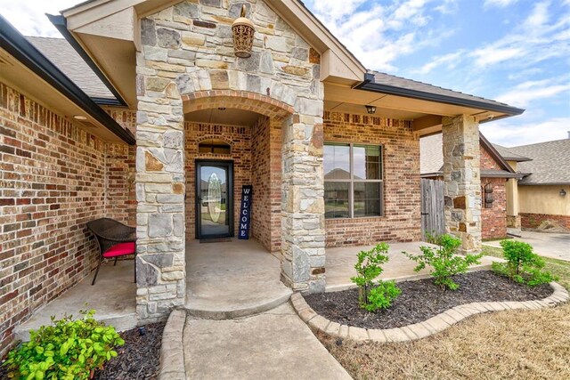 doorway to property with stone siding and brick siding