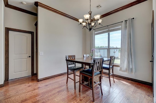 dining room with visible vents, crown molding, baseboards, and a notable chandelier