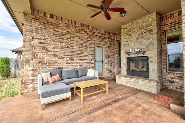 view of patio with an outdoor living space with a fireplace and ceiling fan