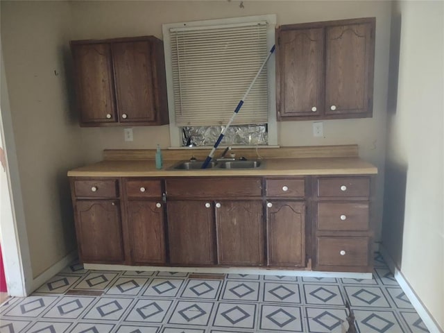 411 E 2nd St, Carnegie, OK 73015 - kitchen featuring a sink, light countertops, baseboards, and light flooring