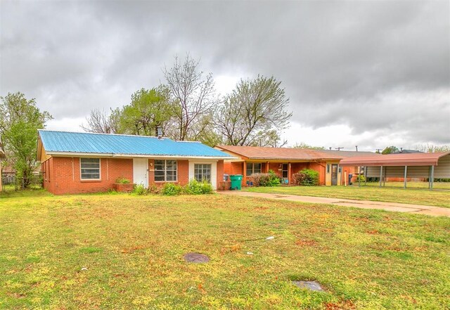 416 NW 81st St, Oklahoma City, OK 73114 - ranch-style home featuring a carport, metal roof, a front lawn, brick siding, and driveway