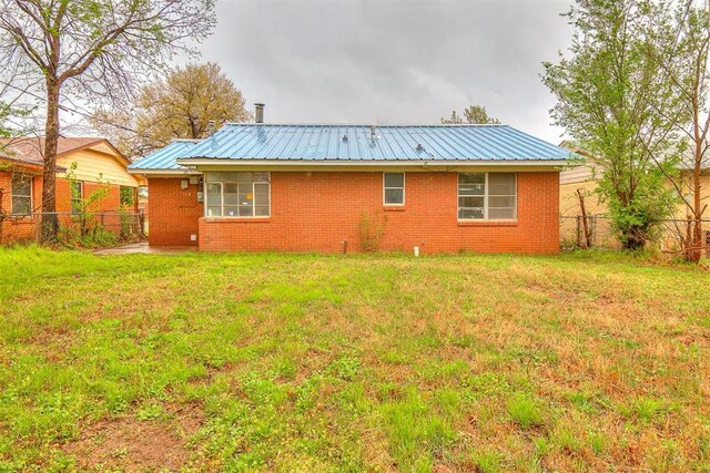 416 NW 81st St, Oklahoma City, OK 73114 - rear view of property featuring fence, metal roof, and a lawn