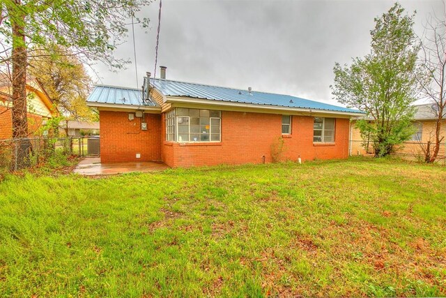 416 NW 81st St, Oklahoma City, OK 73114 - back of property featuring metal roof, a fenced backyard, and a lawn
