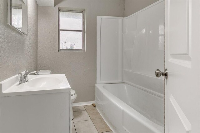 416 NW 81st St, Oklahoma City, OK 73114 - bathroom featuring a textured wall, tile patterned flooring, baseboards, and toilet