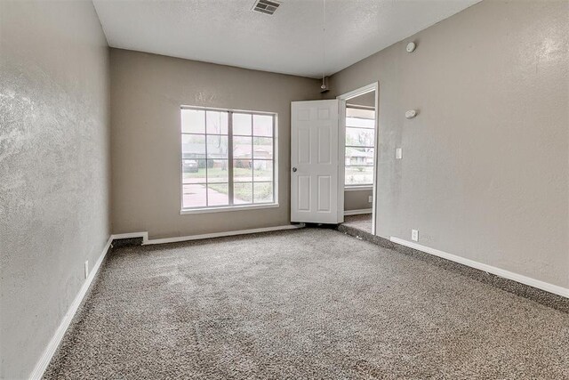 416 NW 81st St, Oklahoma City, OK 73114 - carpeted empty room featuring visible vents, baseboards, a textured wall, and a textured ceiling
