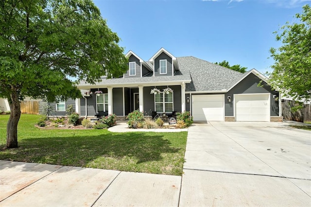 view of front of house with fence, a porch, driveway, and an attached garage