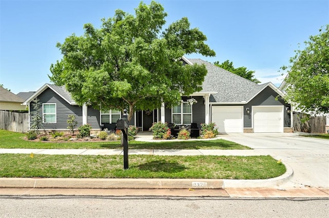 view of front of house featuring fence, a front lawn, driveway, and an attached garage