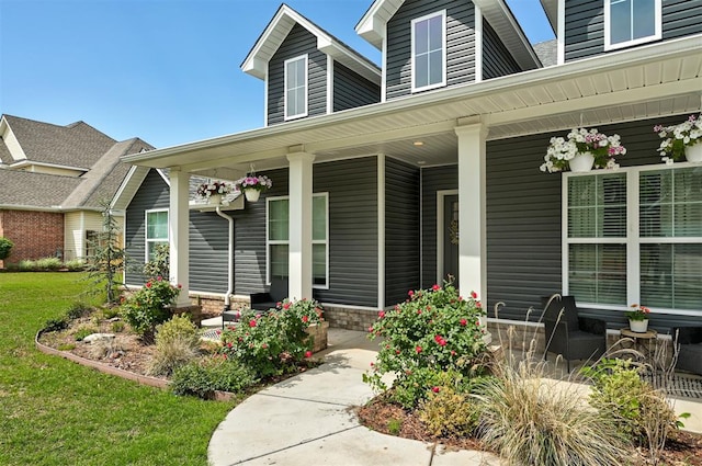 property entrance featuring a porch and a yard