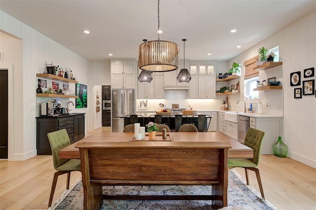 dining room with baseboards, recessed lighting, and light wood-style flooring