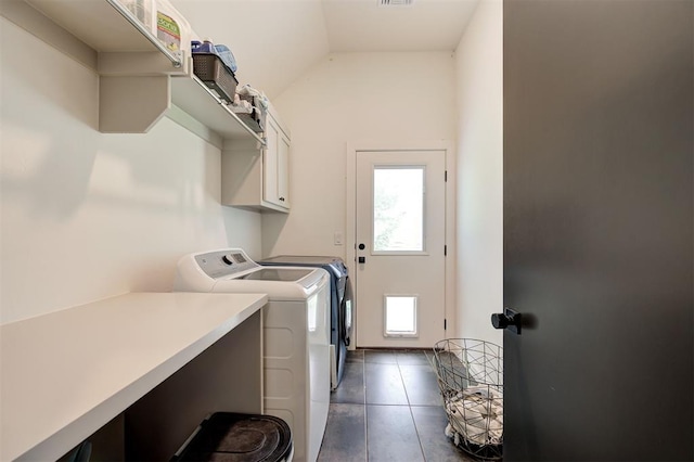 laundry room featuring washer and dryer, cabinet space, visible vents, and dark tile patterned flooring