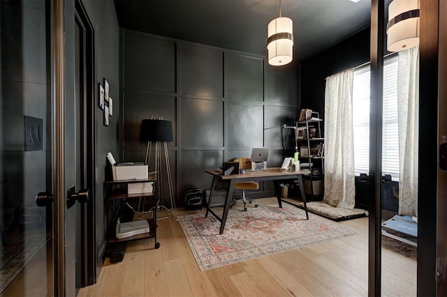 office area featuring french doors, wood finished floors, a decorative wall, and plenty of natural light