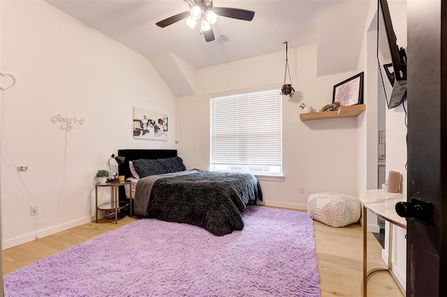 bedroom featuring vaulted ceiling, visible vents, light wood-style flooring, and baseboards