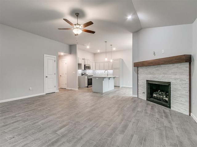 1680 Addington Rd, Newcastle, OK 73065 - unfurnished living room featuring baseboards, light wood-style floors, a sink, and a ceiling fan