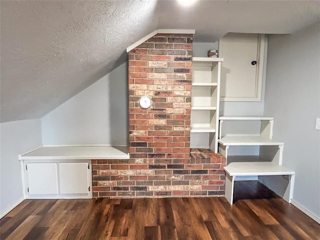 1016 Canyon Ridge Rd, Clinton, OK 73601 - bonus room with lofted ceiling, a textured ceiling, dark wood-style floors, and baseboards
