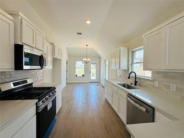 1101 SW 139th St, Oklahoma City, OK 73170 - kitchen with appliances with stainless steel finishes, a sink, vaulted ceiling, a chandelier, and healthy amount of natural light