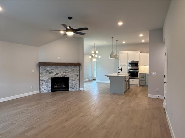 1220 SW 139th St, Oklahoma City, OK 73170 - living area with ceiling fan, light wood-style floors, a stone fireplace, recessed lighting, and lofted ceiling
