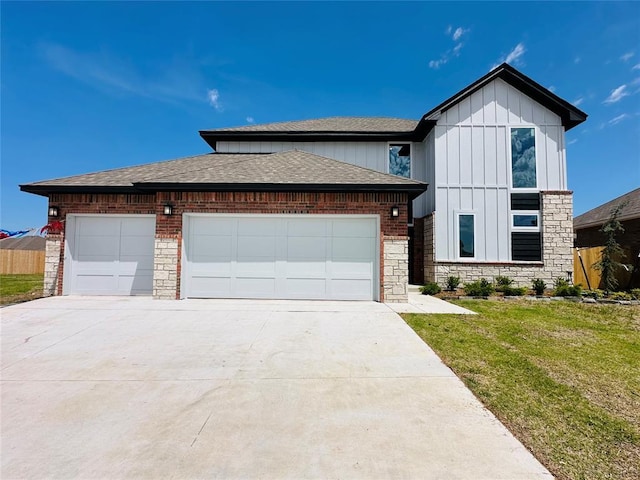 1221 SW 141st St, Oklahoma City, OK 73170 - view of front facade with board and batten siding, roof with shingles, driveway, a garage, and a front lawn