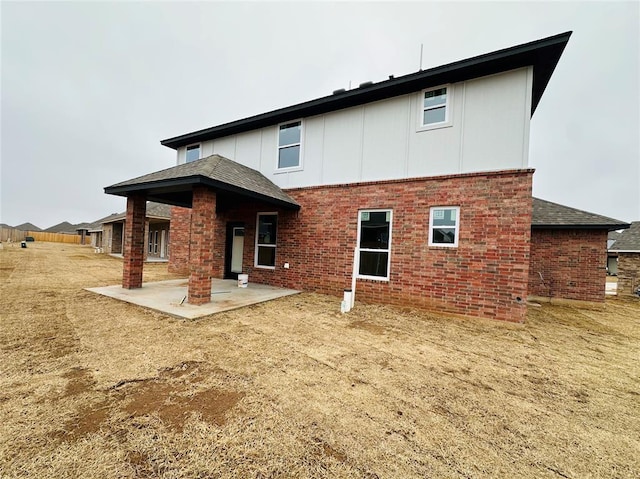 1221 SW 141st St, Oklahoma City, OK 73170 - back of house featuring a patio, brick siding, and board and batten siding