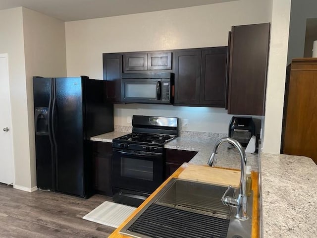 1641 Tumbleweed Way, El Reno, OK 73036 - kitchen with wood finished floors, a sink, baseboards, black appliances, and light countertops