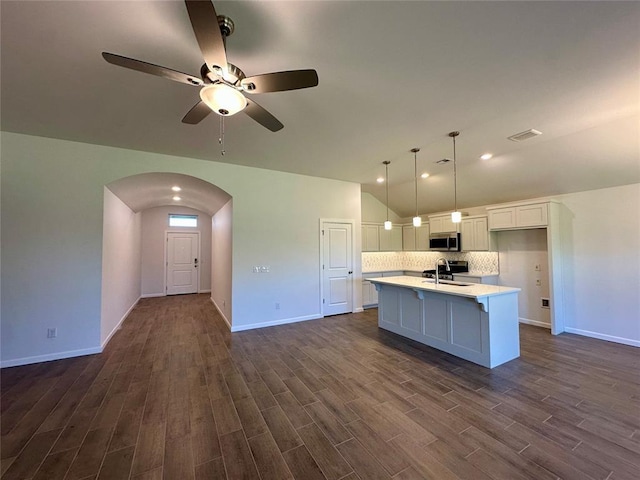 8605 NW 76th St, Oklahoma City, OK 73132 - kitchen featuring stainless steel microwave, a sink, lofted ceiling, dark wood-style floors, and white cabinets