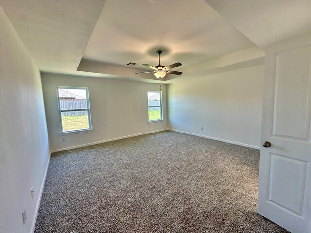 8605 NW 76th St, Oklahoma City, OK 73132 - carpeted spare room featuring ceiling fan, baseboards, and a raised ceiling