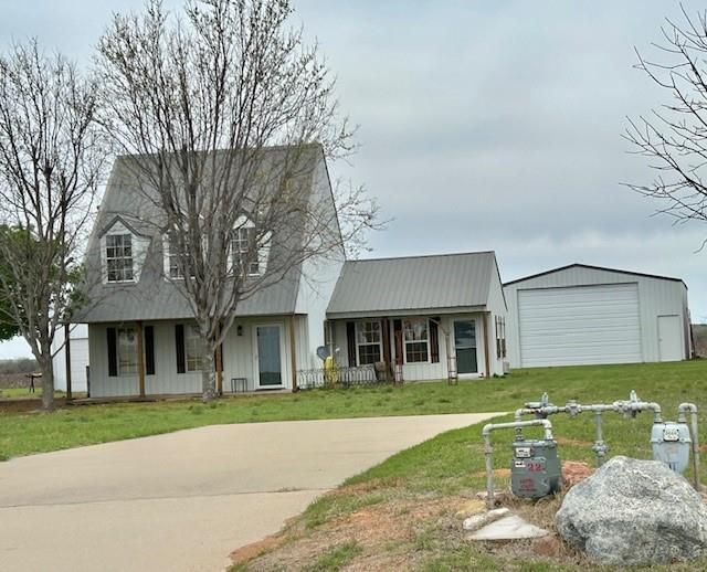 713 Whispering Water Dr, Fort Cobb, OK 73038 - view of front of home with concrete driveway, a front yard, an outbuilding, and covered porch