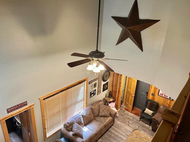713 Whispering Water Dr, Fort Cobb, OK 73038 - living room with wood finished floors, a towering ceiling, and a ceiling fan