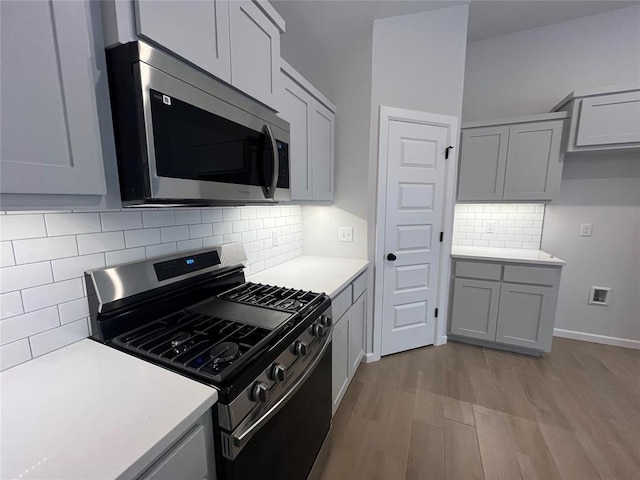 18117 Austin Ct, Edmond, OK 73012 - kitchen with gray cabinets, stainless steel appliances, light wood-style floors, light countertops, and backsplash