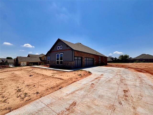10116 NW 100th St, Yukon, OK 73099 - view of property exterior with driveway and stone siding