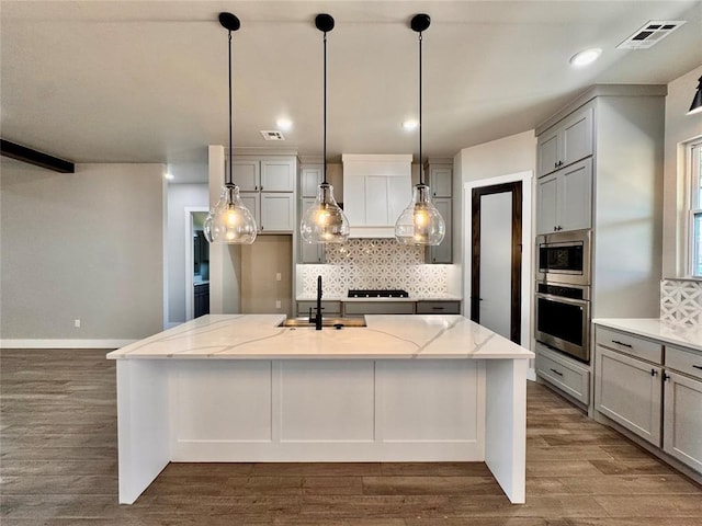 10116 NW 100th St, Yukon, OK 73099 - kitchen featuring appliances with stainless steel finishes, tasteful backsplash, light stone countertops, dark wood-style floors, and recessed lighting