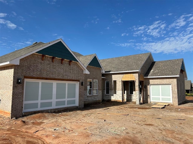 10132 NW 100th St, Yukon, OK 73099 - property under construction with brick siding, roof with shingles, and an attached garage