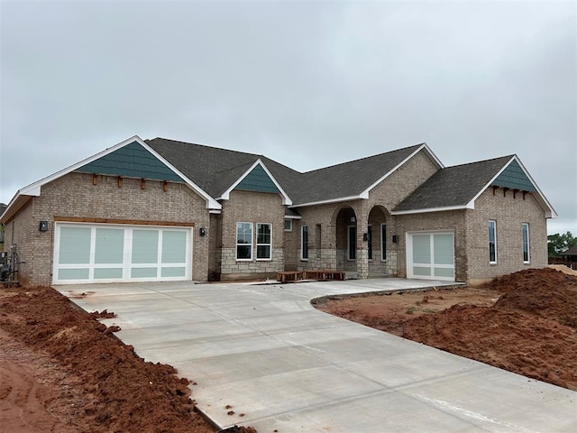10132 NW 100th St, Yukon, OK 73099 - view of front of home with concrete driveway, a garage, brick siding, and roof with shingles