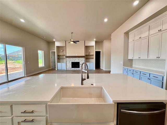 10132 NW 100th St, Yukon, OK 73099 - kitchen featuring decorative backsplash, ceiling fan, open floor plan, a fireplace, and stainless steel dishwasher