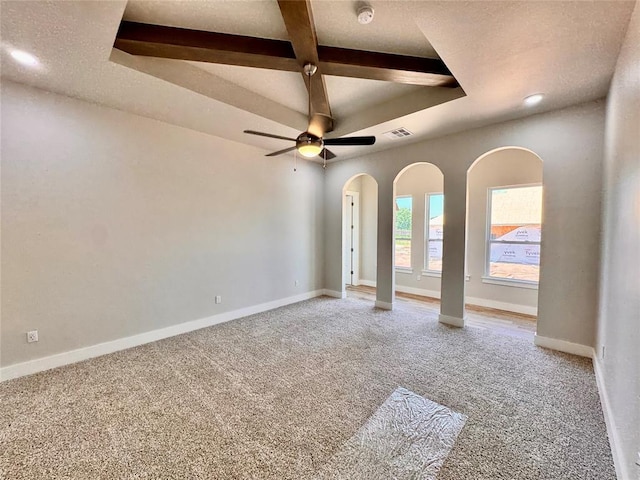 10132 NW 100th St, Yukon, OK 73099 - empty room featuring a ceiling fan, a smoke detector, light carpet, arched walkways, and beam ceiling