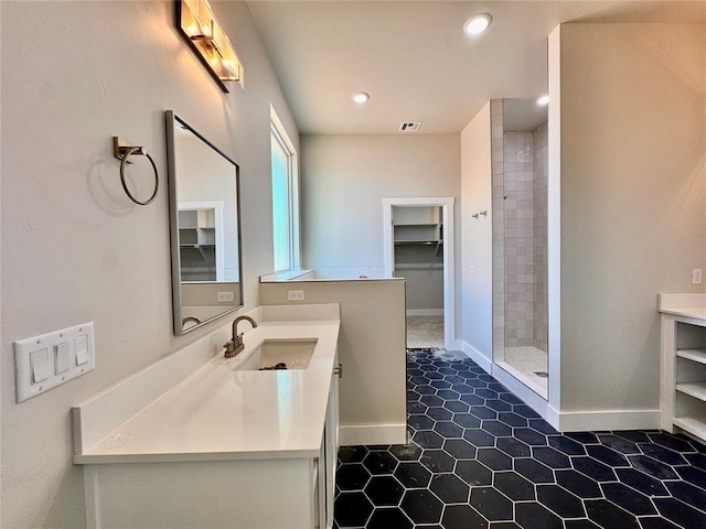 10132 NW 100th St, Yukon, OK 73099 - full bathroom with vanity, a tile shower, a spacious closet, tile patterned floors, and recessed lighting