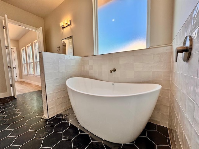 10132 NW 100th St, Yukon, OK 73099 - bathroom featuring tile walls, a soaking tub, and tile patterned floors
