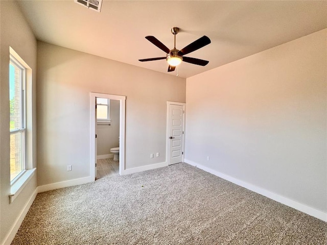 10132 NW 100th St, Yukon, OK 73099 - unfurnished bedroom with light carpet, connected bathroom, and ceiling fan