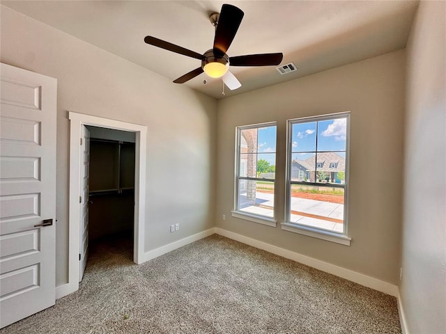 10132 NW 100th St, Yukon, OK 73099 - unfurnished bedroom featuring light carpet, a spacious closet, and a ceiling fan