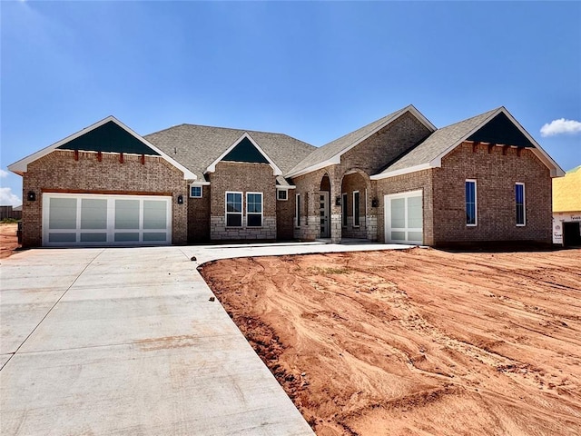 10132 NW 100th St, Yukon, OK 73099 - view of front facade with brick siding, concrete driveway, and a garage