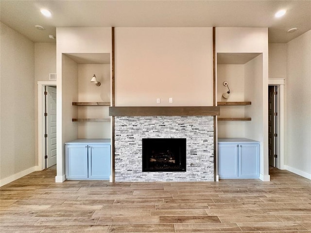 10132 NW 100th St, Yukon, OK 73099 - unfurnished living room with light wood finished floors, a stone fireplace, and recessed lighting