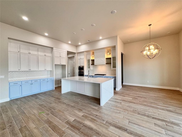 10132 NW 100th St, Yukon, OK 73099 - kitchen featuring tasteful backsplash, a chandelier, light countertops, light wood-style floors, and recessed lighting