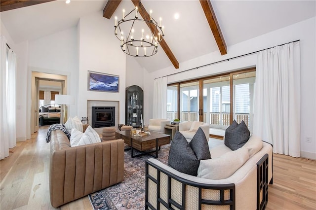 living room with high vaulted ceiling, an inviting chandelier, light wood finished floors, and beamed ceiling