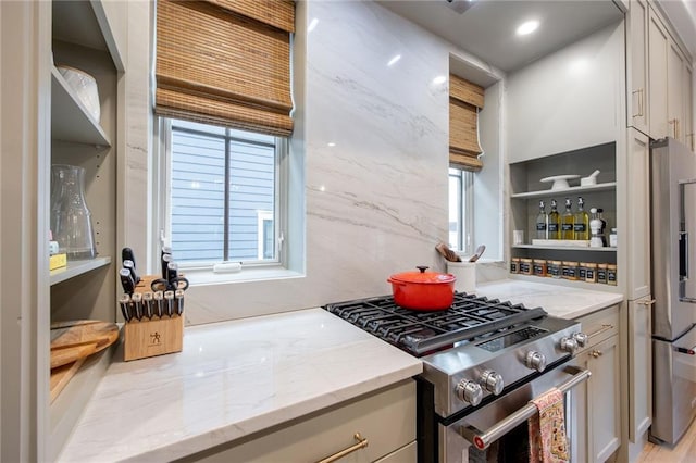 kitchen featuring open shelves, plenty of natural light, light stone countertops, and appliances with stainless steel finishes