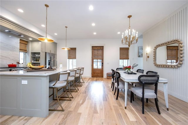 dining space featuring a notable chandelier, light wood finished floors, and a healthy amount of sunlight