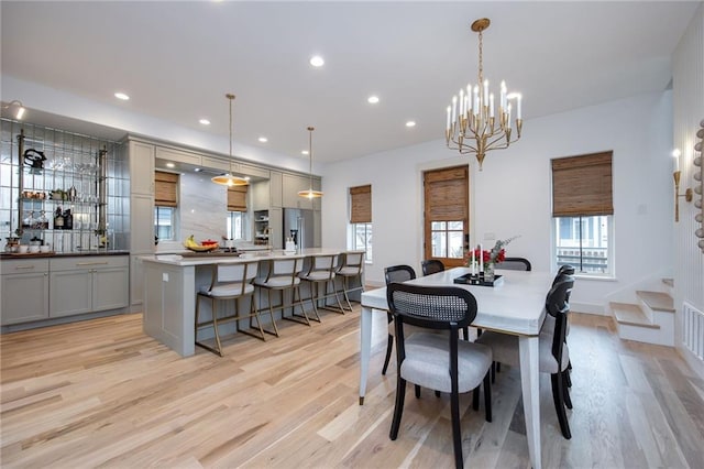 dining area featuring stairs, light wood-style flooring, recessed lighting, and a chandelier