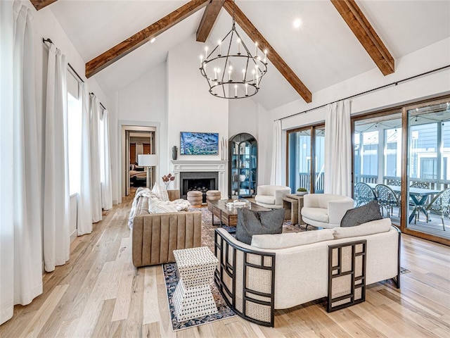 living room featuring light wood-style floors, beam ceiling, a notable chandelier, and high vaulted ceiling
